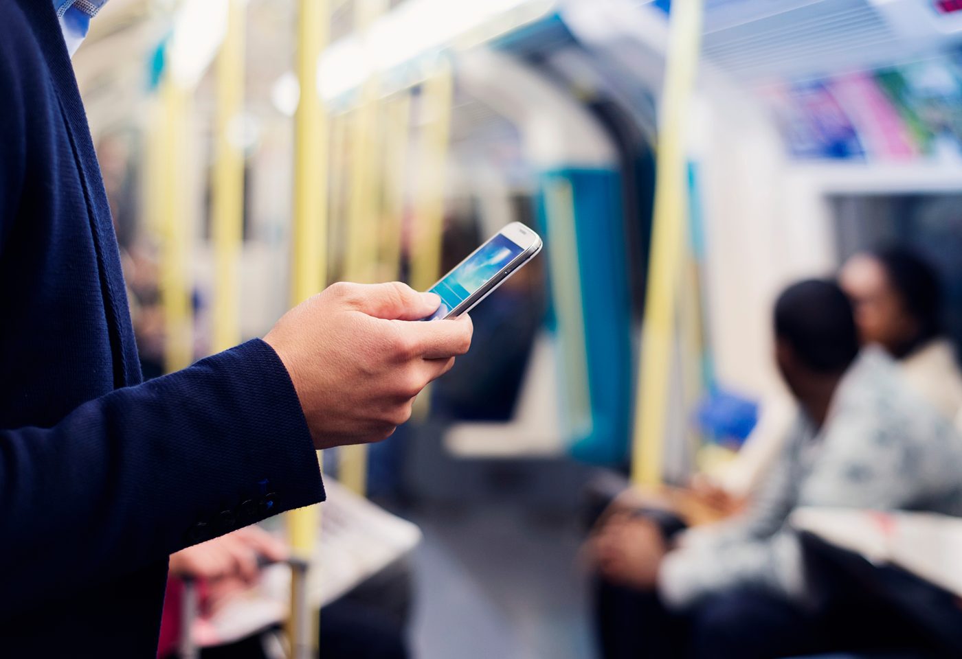 Commuter using a smartphone on a train